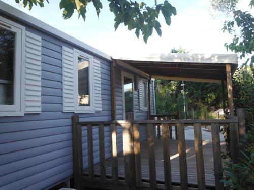 a deck with a pergola next to a house at Camping l'Eléphant in Saint-Raphaël