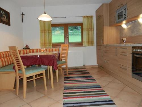 a kitchen with a table and chairs in a kitchen at Riedlhof in Kössen