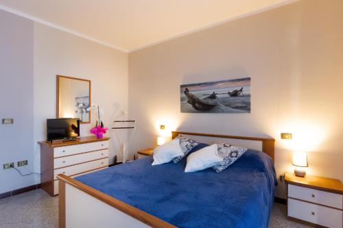 a bedroom with a blue bed and a television at CASA ROSA & LUISA in Pozzolengo