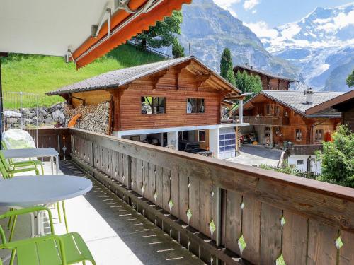 a wooden house with a table and chairs on a balcony at Apartment Chalet Bienli Mitte by Interhome in Grindelwald