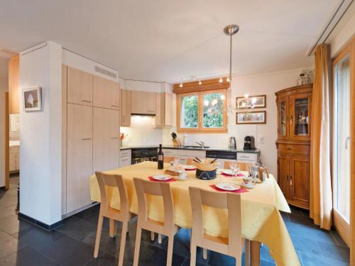uma cozinha com uma mesa e algumas cadeiras e uma cozinha com em Apartment Silberhorn-1 by Interhome em Wengen