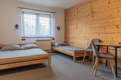 a room with two beds and a table in it at Black Deer in Czarna Góra