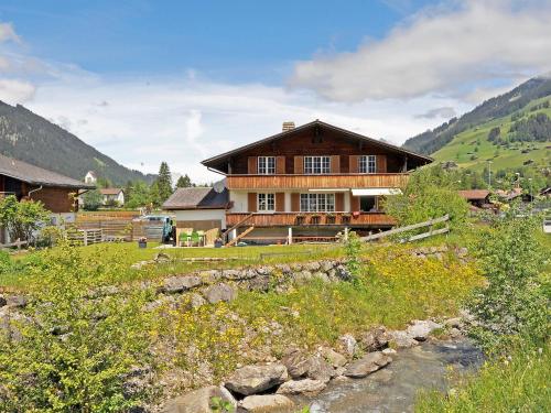 una gran casa de madera en una colina junto a un río en Apartment Lischmatte A by Interhome en Lenk