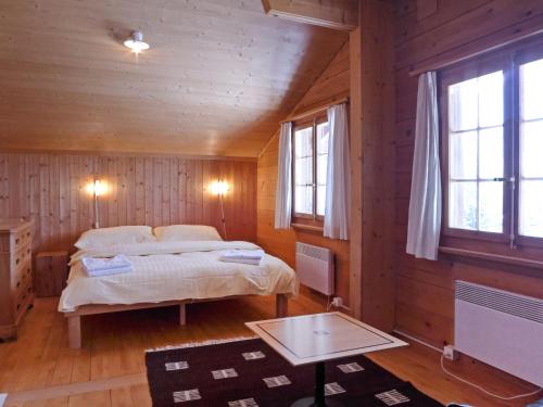 a bedroom with two beds in a wooden cabin at Chalet Wätterlücke by Interhome in Wengen