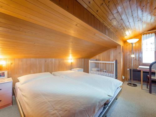 ein großes Bett in einem Zimmer mit Holzdecke in der Unterkunft Apartment Eigersonne by Interhome in Wengen
