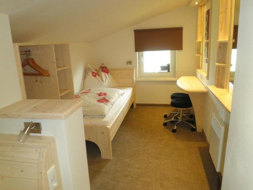 a small bedroom with a bed and a desk at Bio-Bauernhof Reitmayrgut in Goldegg