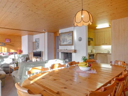 Il comprend une cuisine et une salle à manger avec une table et des chaises en bois. dans l'établissement Apartment Chäs Gruebi by Interhome, à Wengen