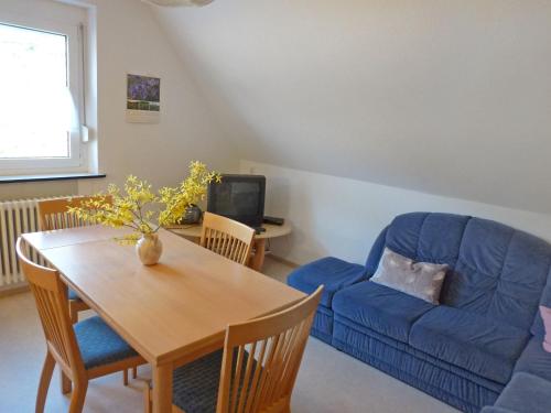 a living room with a table and a blue couch at Apartment Fischer by Interhome in Eisenbach