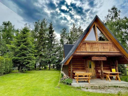 a log cabin with a picnic table in a field at U Leona in Gorlice