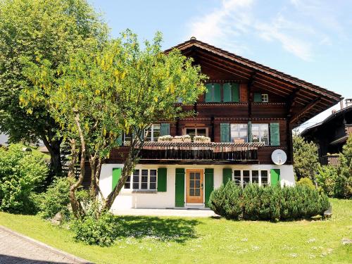 una casa con un árbol delante de ella en Apartment Firstli by Interhome en Lenk