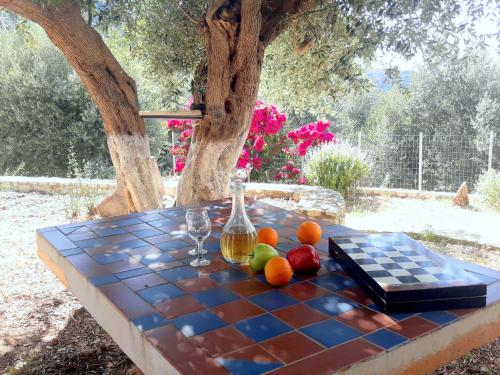 a table with fruit on top of a checker board at OliveTree House in Vathi