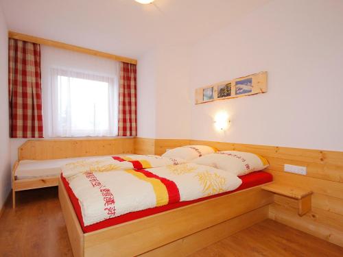 ein Schlafzimmer mit einem Holzbett mit Kissen darauf in der Unterkunft Apartment Marina-3 by Interhome in Mühlfeld