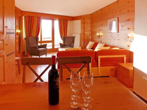 a room with a bed and two wine glasses on a table at Apartment Le Bristol B52 by Interhome in Villars-sur-Ollon