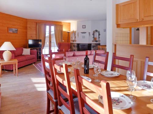 ein Esszimmer mit einem Tisch und einer Flasche Wein in der Unterkunft Apartment Le Miclivier B2 by Interhome in Villars-sur-Ollon