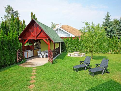 einen Hinterhof mit einem Pavillon und zwei Stühlen in der Unterkunft Chalet Nero by Interhome in Balatonmáriafürdő
