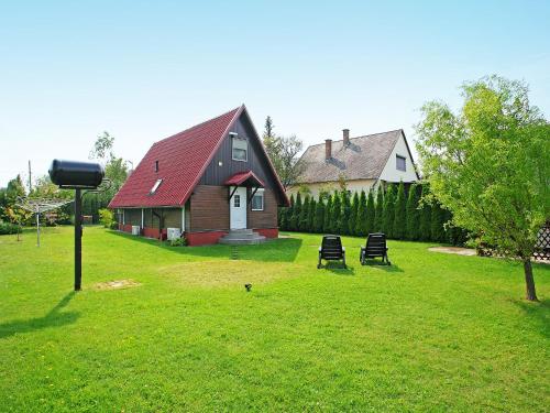 ein Haus mit rotem Dach auf einem grünen Rasen in der Unterkunft Chalet Nero by Interhome in Balatonmáriafürdő