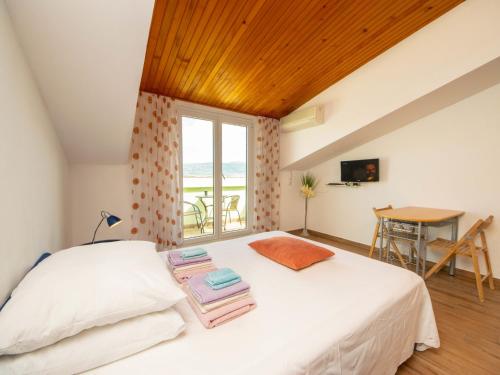 1 dormitorio con 1 cama blanca y ventana en Apartment Šarić-2 by Interhome, en Trogir