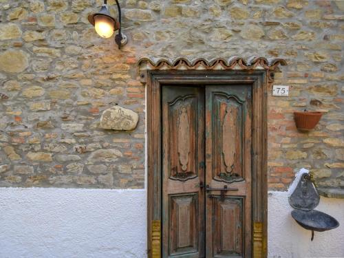 a wooden door on the side of a stone building at Holiday Home Casale Antica Pietra by Interhome in Gemmano