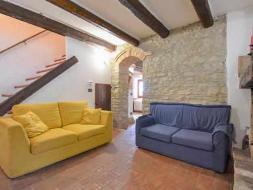 a living room with a yellow couch and a blue couch at Holiday Home Casale Antica Pietra by Interhome in Gemmano