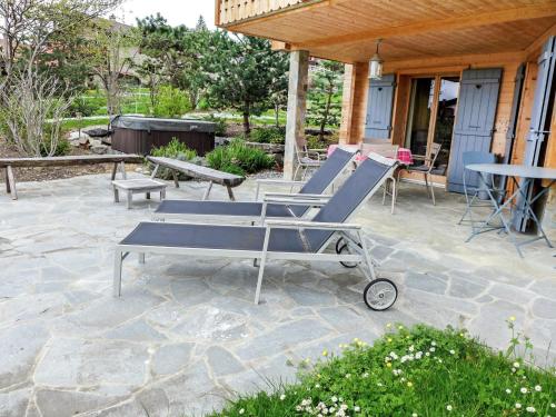 a patio with two lounge chairs and a table at Chalet Les 3 Soeurs by Interhome in Villars-sur-Ollon