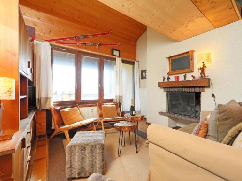 a living room with a couch and a fireplace at Apartment Les Petites Maraîches 132-389 by Interhome in Taveyannaz