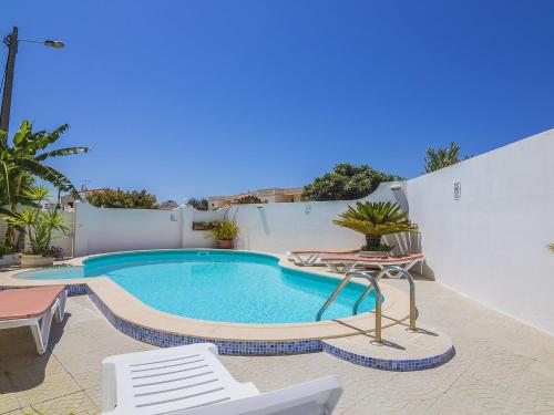 een zwembad met 2 stoelen en een tafel bij Villa Villa Quinta do Sol by Interhome in Armação de Pêra