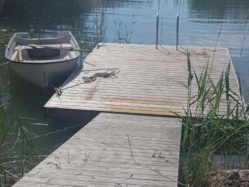 een boot is vastgebonden aan een dok op het water bij Holiday Home Korvenniemi by Interhome in Töfsala