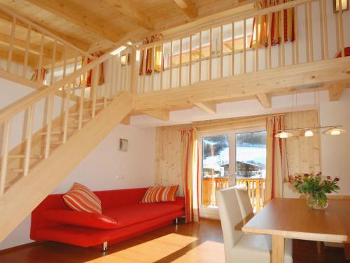 uma sala de estar com um sofá vermelho e uma escada em Apartment Dahoam-2 by Interhome em Forstau