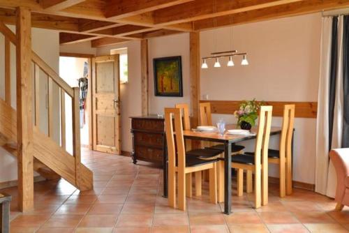 Un comedor con mesa y sillas de madera. en Haus Solvig, en Fehmarn