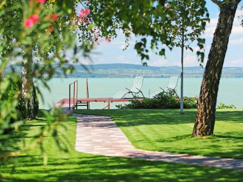 a park with a bench and a view of the water at Apartment Lakefront 1 by Interhome in Balatonlelle