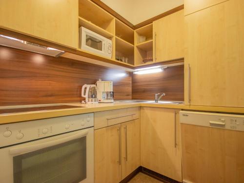 a kitchen with white appliances and wooden cabinets at Apartment Alpin-7 by Interhome in Sölden