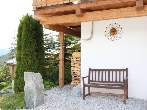 a wooden bench sitting under a wooden pergola at Chalet Königsleiten 3 by Interhome in Königsleiten