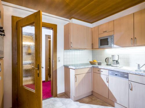 kuchnia z drzwiami otwieranymi do kuchni z białymi szafkami w obiekcie Apartment Christian-1 by Interhome w mieście Maurach