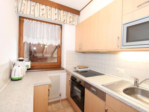 eine kleine Küche mit einem Waschbecken und einem Fenster in der Unterkunft Apartment Christian-2 by Interhome in Maurach