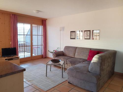 a living room with a couch and a table at Apartment Berg-Seeblick by Interhome in Sundlauenen