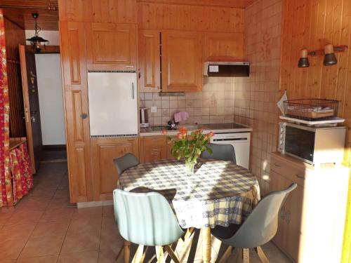 een keuken met een tafel en stoelen en een keuken met een koelkast bij Apartment Centaure A RS 3 by Interhome in Ovronnaz