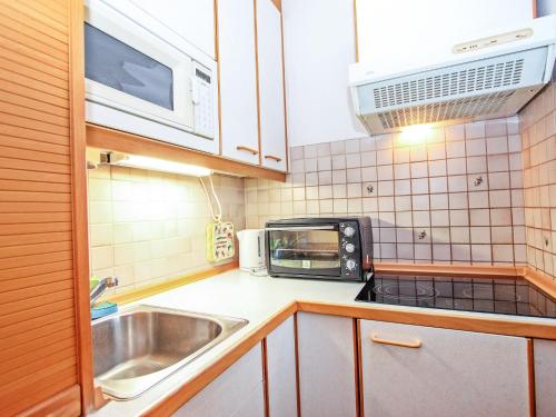 una pequeña cocina con fregadero y microondas en Apartment Alpenland-14 by Interhome, en Seefeld in Tirol