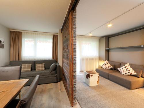 un soggiorno con 2 divani e un tavolo di Apartment Grillon-3 by Interhome a Zermatt