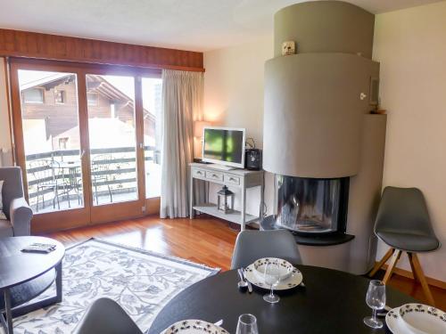 a living room with a fireplace and a table and chairs at Apartment Villars Soleil B15 by Interhome in Villars-sur-Ollon