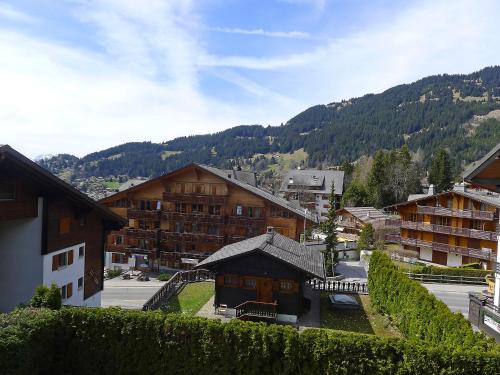 a view of a town with buildings and a mountain at Apartment Villars Soleil B15 by Interhome in Villars-sur-Ollon