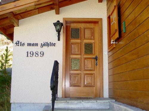 a door to a house with a sign on it at Chalet Als man zählte 1989 by Interhome in Gasenried