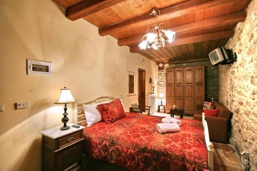 a bedroom with a bed with a red blanket at Archontiko Kolokotroni in Stemnitsa