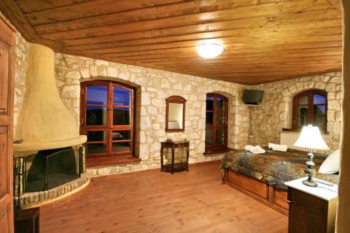 Großes Zimmer mit einem Bett und einem TV. in der Unterkunft Archontiko Kolokotroni in Stemnitsa