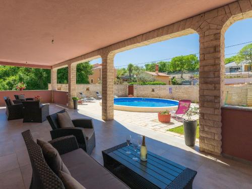 een patio met stoelen en een zwembad op de achtergrond bij Holiday Home Ljiljana by Interhome in Rakalj