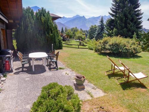 a patio with a table and chairs in a yard at Chalet Chalet Lorila by Interhome in Villars-sur-Ollon