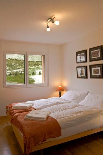 a bedroom with a large bed with two windows at Apartment A31 by Interhome in Leukerbad
