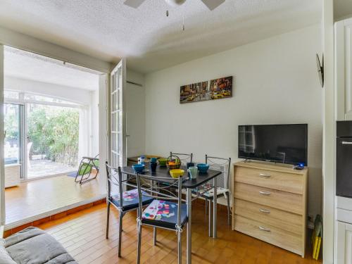 un salon avec une table et une télévision dans l'établissement Studio Résidence Green Village 2 by Interhome, au Cap d'Agde