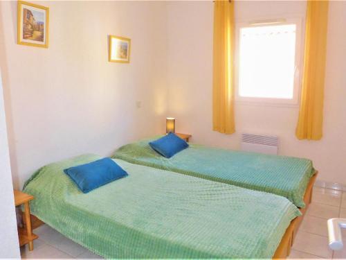 deux lits jumeaux dans une chambre avec fenêtre dans l'établissement Holiday Home Plein Sud by Interhome, à Narbonne-Plage
