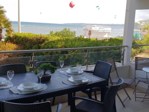 - une table avec des assiettes et des verres sur un balcon donnant sur l'océan dans l'établissement Apartment Lerins by Interhome, à Cannes
