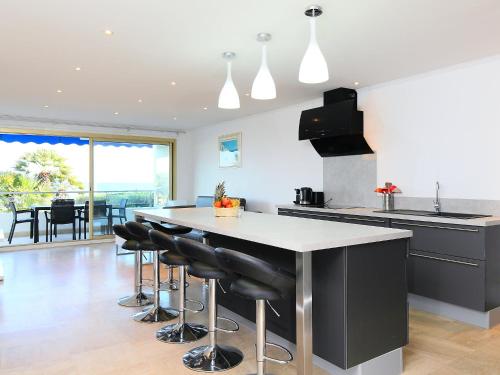 een keuken met een groot eiland met zwarte barkrukken bij Apartment Lerins by Interhome in Cannes